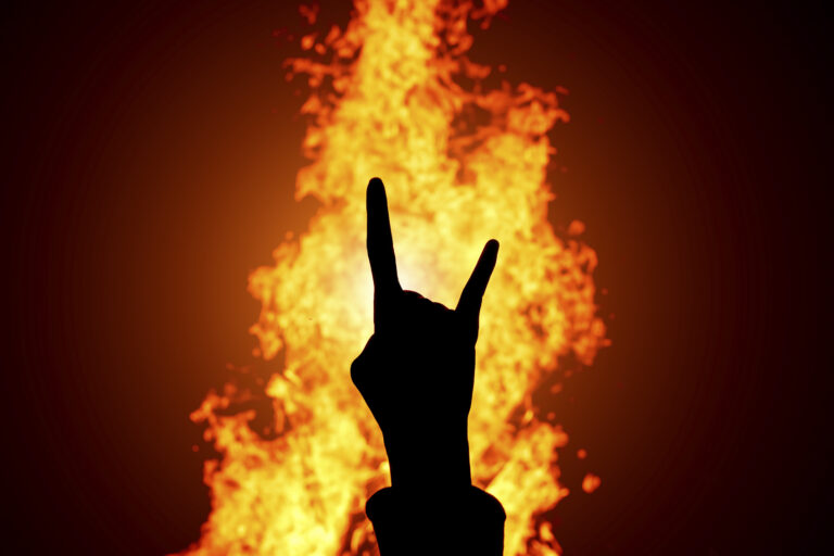 Silhouette of Rock and Roll hand sign against the fire background